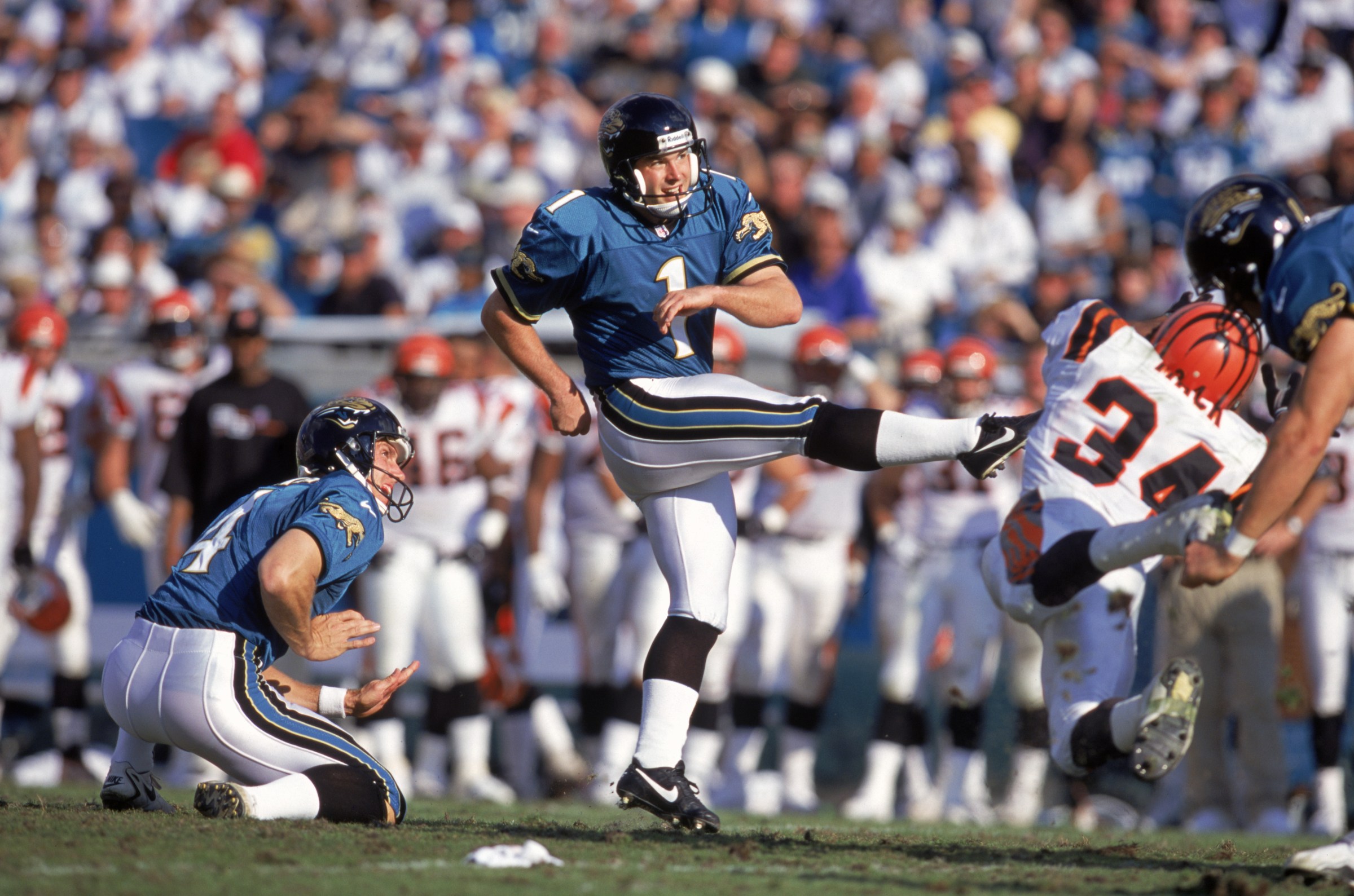 JACKSONVILLE, FL Ð JANUARY 2: Place kicker Mike Hollis #1 of the Jacksonville Jaguars kick from the hold by Bryan Barker #4 during a NFL game against the Cincinnati Bengals at Alltel Stadium on January 2, 1999 in Jacksonville, Florida. The Jags defeated the Bengals 24-7. (Photo by Andy Lyons/Getty Images)