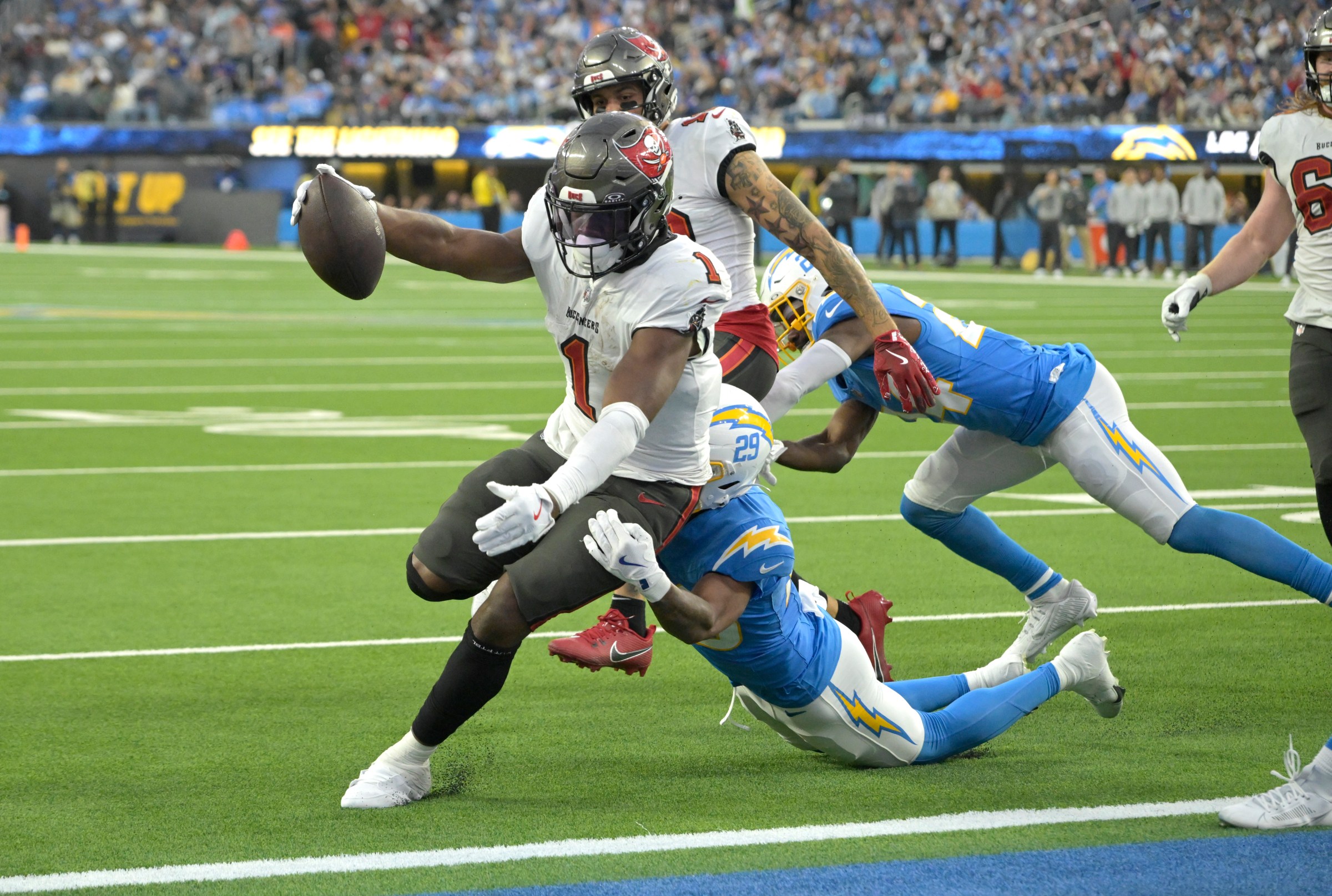Dec 15, 2024; Inglewood, California, USA; Tampa Bay Buccaneers running back Rachaad White (1) drags Los Angeles Chargers cornerback Tarheeb Still (29) into the end zone as he runs for a touchdown in the second half at SoFi Stadium. Mandatory Credit: Jayne Kamin-Oncea-Imagn Images