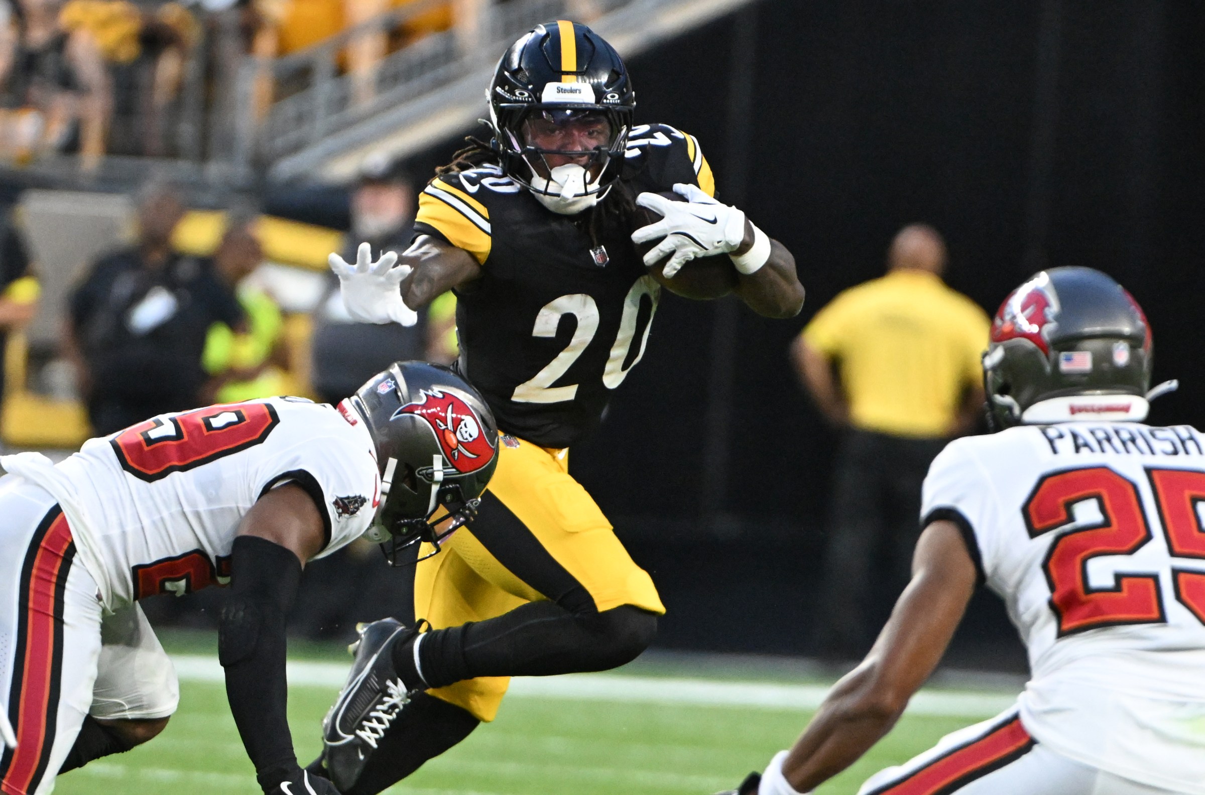 Aug 16, 2025; Pittsburgh, Pennsylvania, USA; Pittsburgh Steelers running back Kaleb Johnson (20) looks to stiff arm Tampa Bay Buccaneers safety Christian Izien (29) during the second quarter at Acrisure Stadium. Mandatory Credit: Barry Reeger-Imagn Images
