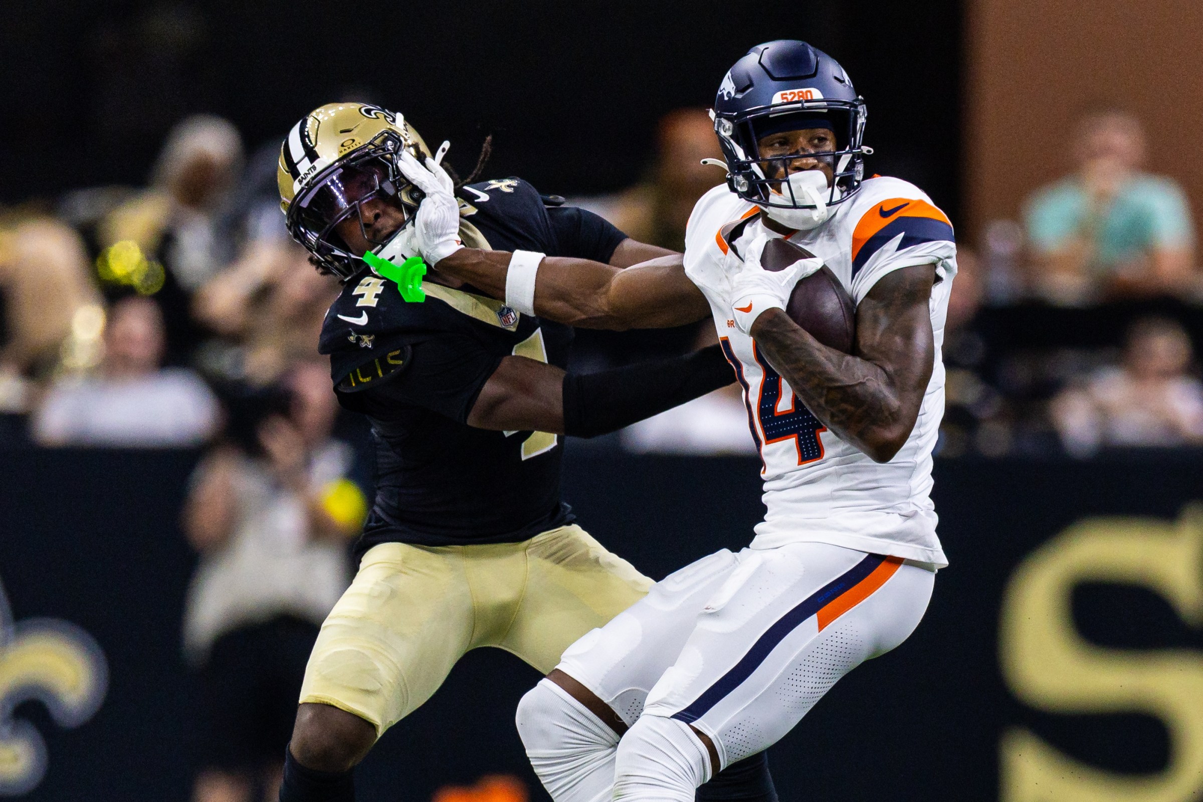 Aug 23, 2025; New Orleans, Louisiana, USA; Denver Broncos wide receiver Courtland Sutton (14) pushes away New Orleans Saints cornerback Kool-Aid McKinstry (4) during the first half at Caesars Superdome. Mandatory Credit: Stephen Lew-Imagn Images