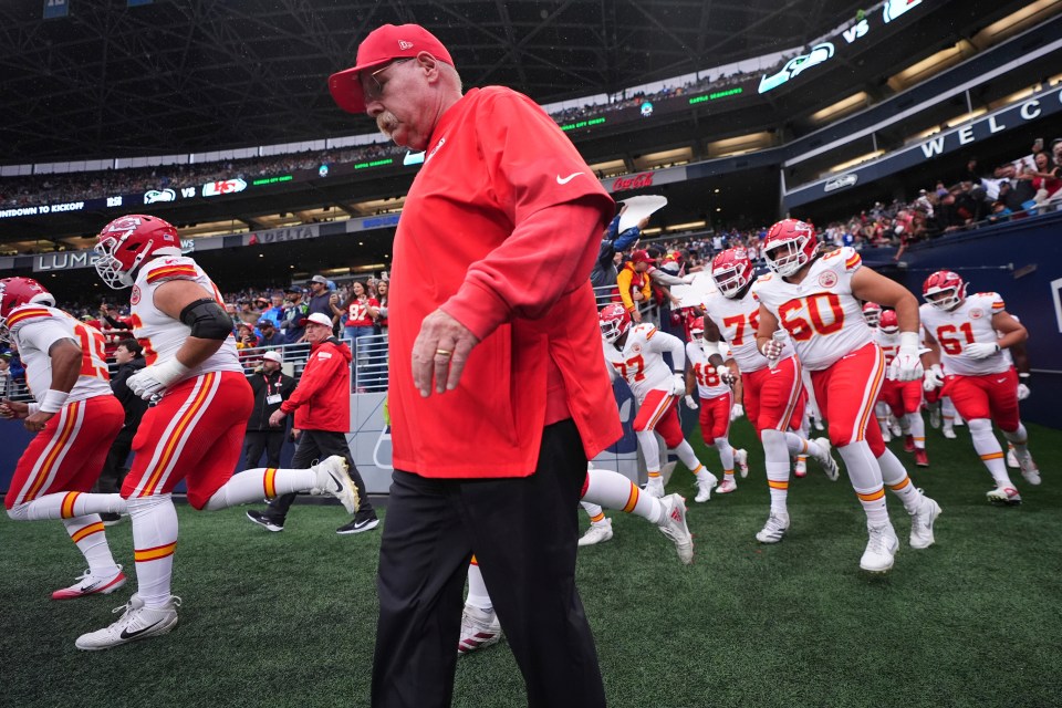 Kansas City Chiefs head coach Andy Reid walking onto the field with his team.