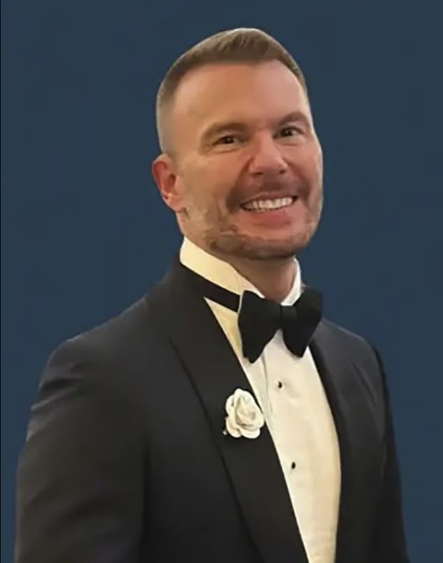 Portrait of Matthew Rooney in a tuxedo.