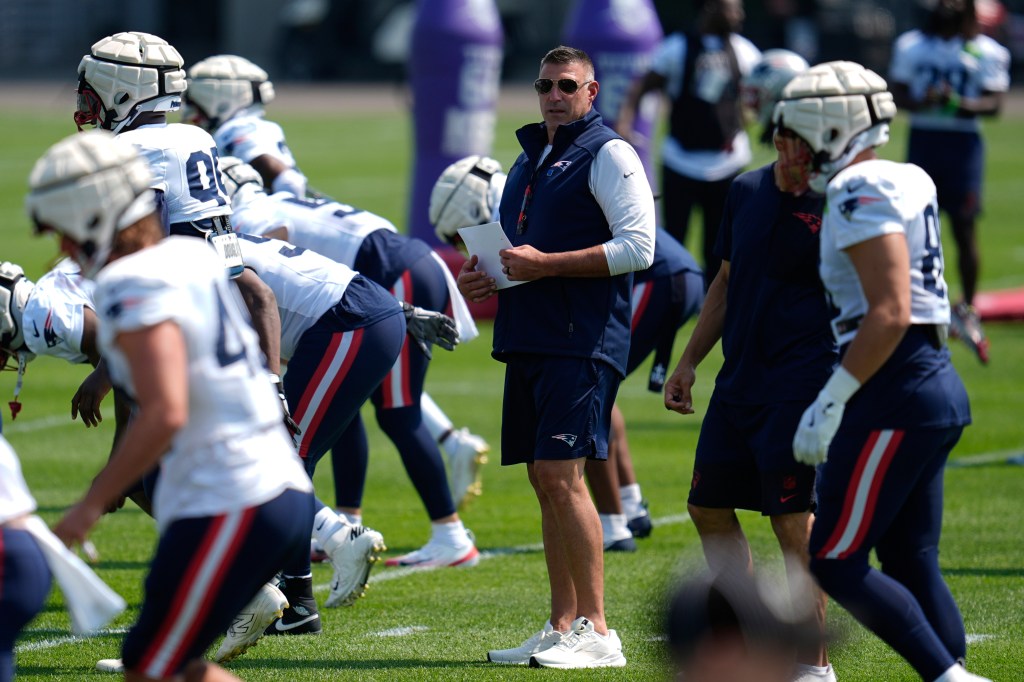 New England Patriots coach watching players during practice.