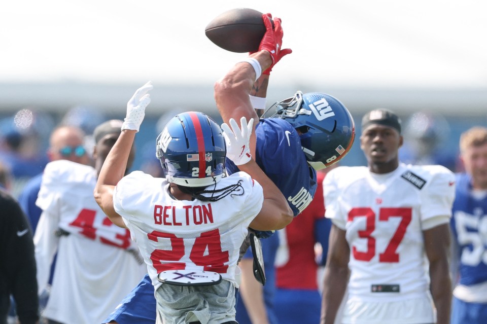New York Giants tight end Theo Johnson making a catch during training camp, with safety Dane Belton defending.