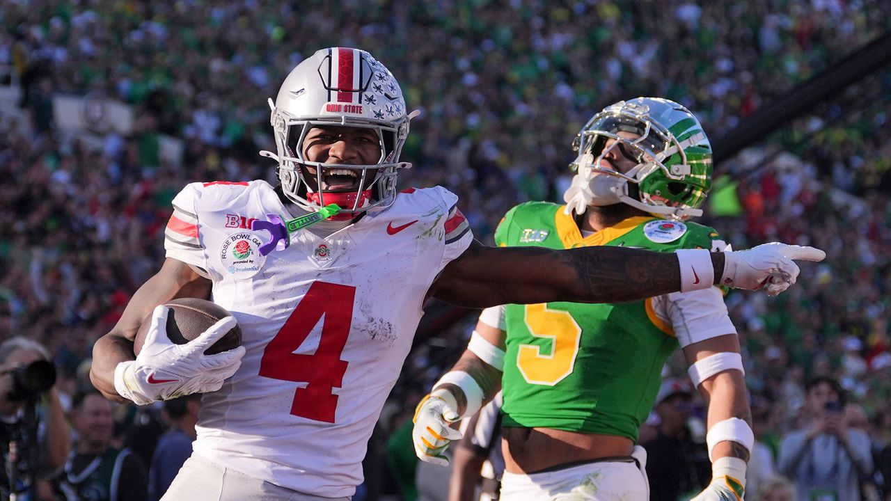 Ohio State wide receiver Jeremiah Smith (4) scores a touchdown against Oregon defensive back Kobe Savage (5) during the first half in the quarterfinals of the Rose Bowl College Football Playoff, Wednesday, Jan. 1, 2025, in Pasadena, Calif. (AP Photo/Mark J. Terrill, File)
