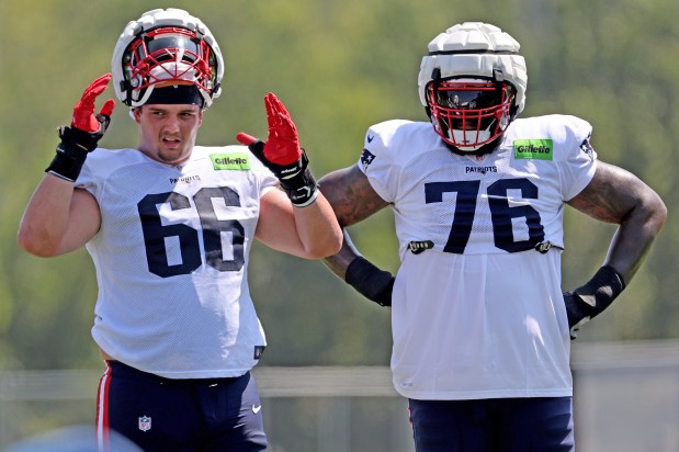Offensive tackles Will Campbell (66) and Morgan Moses look on during Monday's practice. (Photo By Matt Stone/Boston Herald)