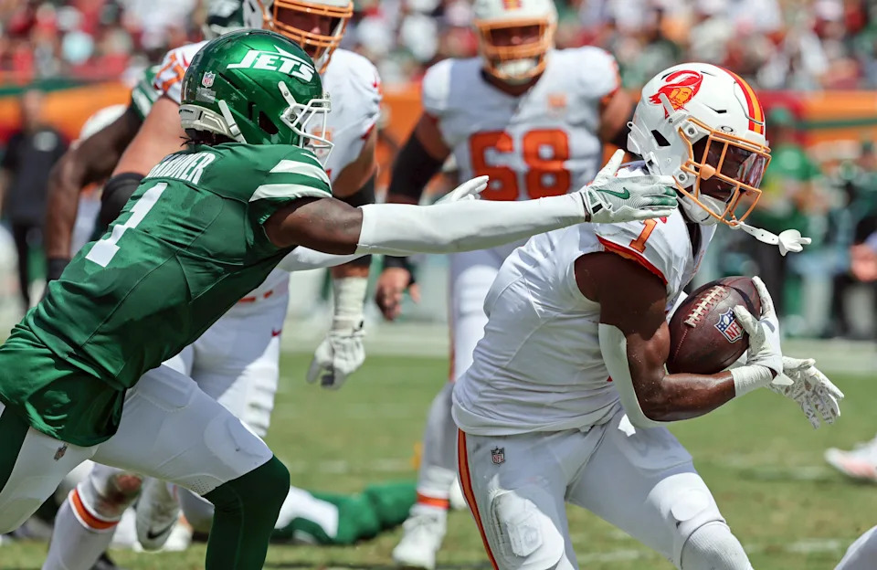 Sep 21, 2025; Tampa, Florida, USA; Tampa Bay Buccaneers running back Rachaad White (1) runs with the ball as New York Jets cornerback Sauce Gardner (1) defends during the second quarter at Raymond James Stadium. Mandatory Credit: Kim Klement Neitzel-Imagn Images