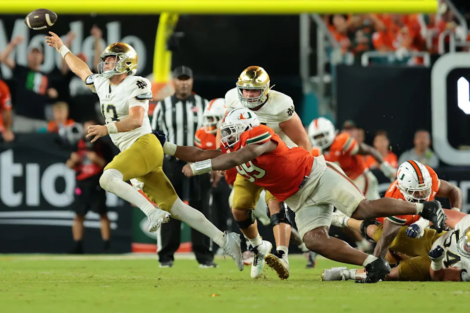 Aug 31, 2025; Miami Gardens, Florida, USA; Notre Dame Fighting Irish quarterback CJ Carr (13) throws the ball to avoid a sack against the Miami Hurricanes at Hard Rock Stadium. Mandatory Credit: Sam Navarro-Imagn Images