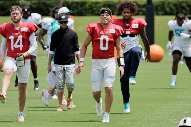 Miami Dolphins quarterbacks Quinn Ewers, Zach Wilson, and Tua Tagovailoa...