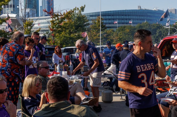 Fans tailgate outside Soldier Field before the Bears play the...