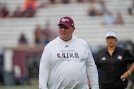Texas A&M head coach Mike Elko watches players warm up before an NCAA college football game...