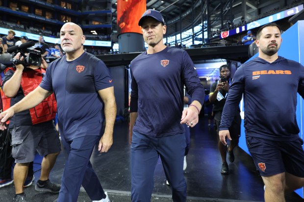 Bears coach Ben Johnson, center, reaches the field for a...