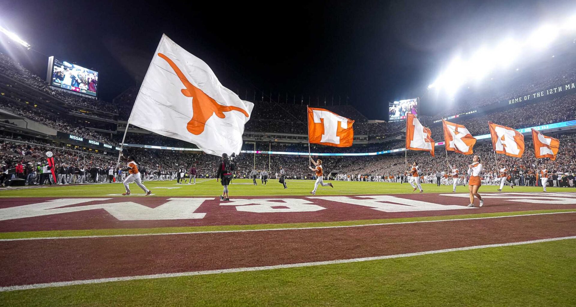 The Texas Longhorns cheerleaders run flags across the field after a score during the Lone Star Showdown against the Texas A&M Aggies at Kyle Field on Saturday, Nov. 30, 2024 in College Station, Texas.