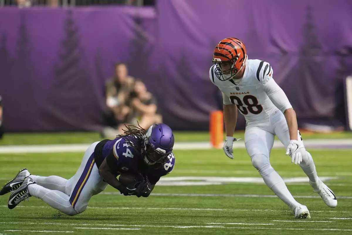 Minnesota Vikings' Josh Metellus (44) makes an interception against Cincinnati Bengals tight end Mike Gesicki (88) during the second half of an NFL football game, Sunday, Sept. 21, 2025, in Minneapolis. (AP Photo/Mike Stewart)