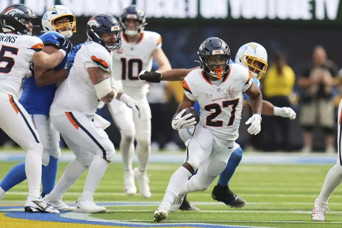 Denver Broncos running back J.K. Dobbins (27) carries during the second half an NFL football game against the Los Angeles Chargers, Sunday, Sept. 21, 2025, in Inglewood, Calif. (AP Photo/Gregory Bull)