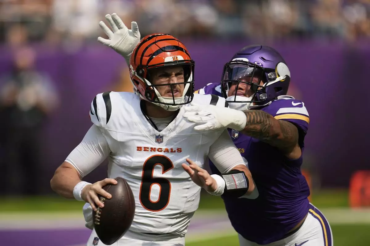 Cincinnati Bengals quarterback Jake Browning (6) is chased by Minnesota Vikings linebacker Ivan Pace Jr. during the first half of an NFL football game, Sunday, Sept. 21, 2025, in Minneapolis. (AP Photo/Mike Stewart)