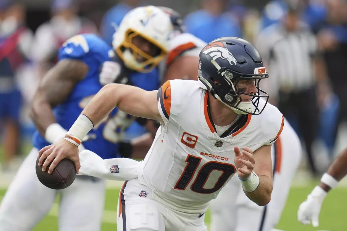 Denver Broncos quarterback Bo Nix (10) rolls out during the first half of an NFL football game against the Los Angeles Chargers, Sunday, Sept. 21, 2025, in Inglewood, Calif. (AP Photo/Gregory Bull)