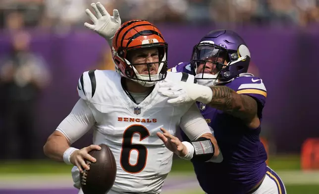 Cincinnati Bengals quarterback Jake Browning (6) is chased by Minnesota Vikings linebacker Ivan Pace Jr. during the first half of an NFL football game, Sunday, Sept. 21, 2025, in Minneapolis. (AP Photo/Mike Stewart)