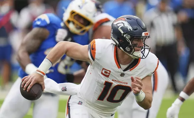 Denver Broncos quarterback Bo Nix (10) rolls out during the first half of an NFL football game against the Los Angeles Chargers, Sunday, Sept. 21, 2025, in Inglewood, Calif. (AP Photo/Gregory Bull)