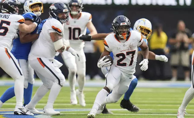 Denver Broncos running back J.K. Dobbins (27) carries during the second half an NFL football game against the Los Angeles Chargers, Sunday, Sept. 21, 2025, in Inglewood, Calif. (AP Photo/Gregory Bull)