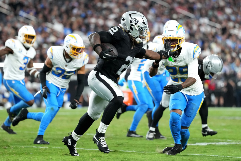 Ashton Jeanty #2 of the Las Vegas Raiders stiff arms Tarheeb Still #29 of the Los Angeles Chargers during the third quarter at Allegiant Stadium on September 15, 2025 in Las Vegas, Nevada.