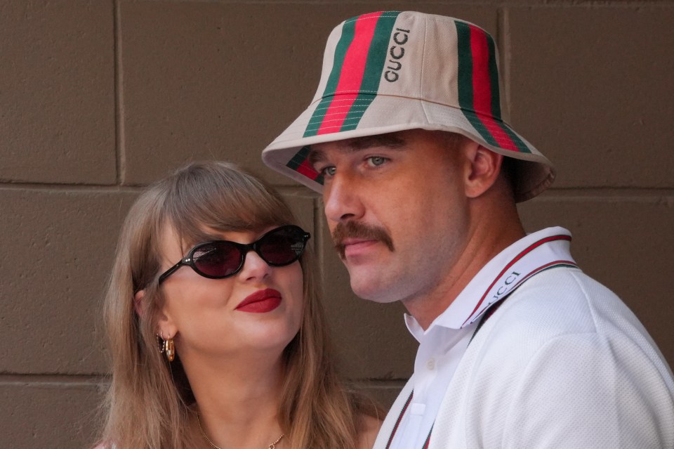 Taylor Swift in sunglasses and red lipstick next to Travis Kelce in a Gucci bucket hat.