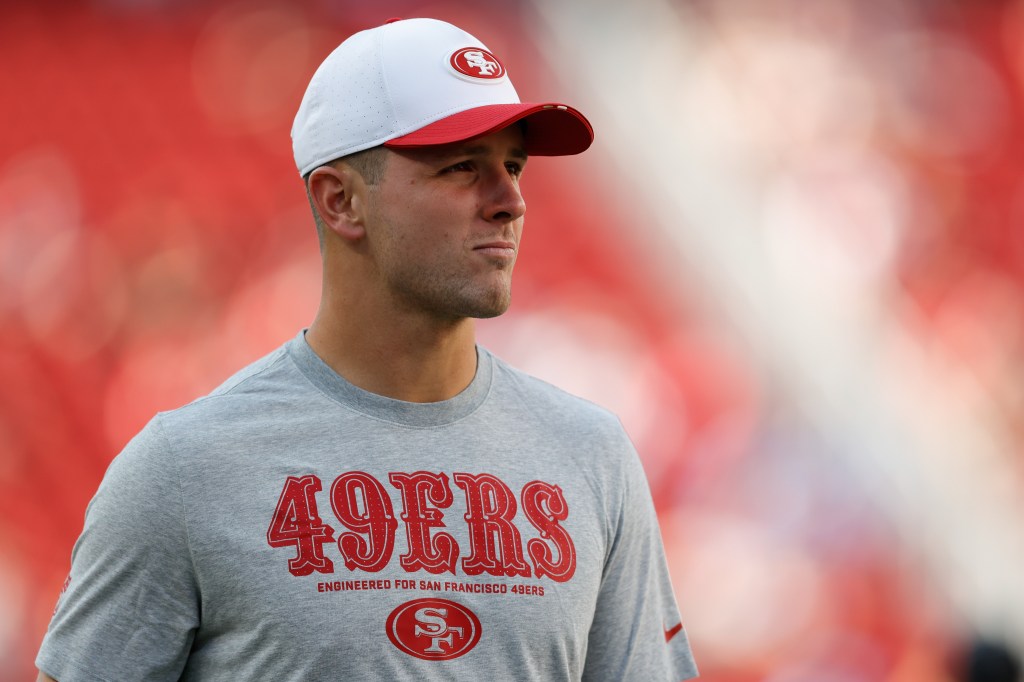 A man wearing a San Francisco 49ers shirt and cap.