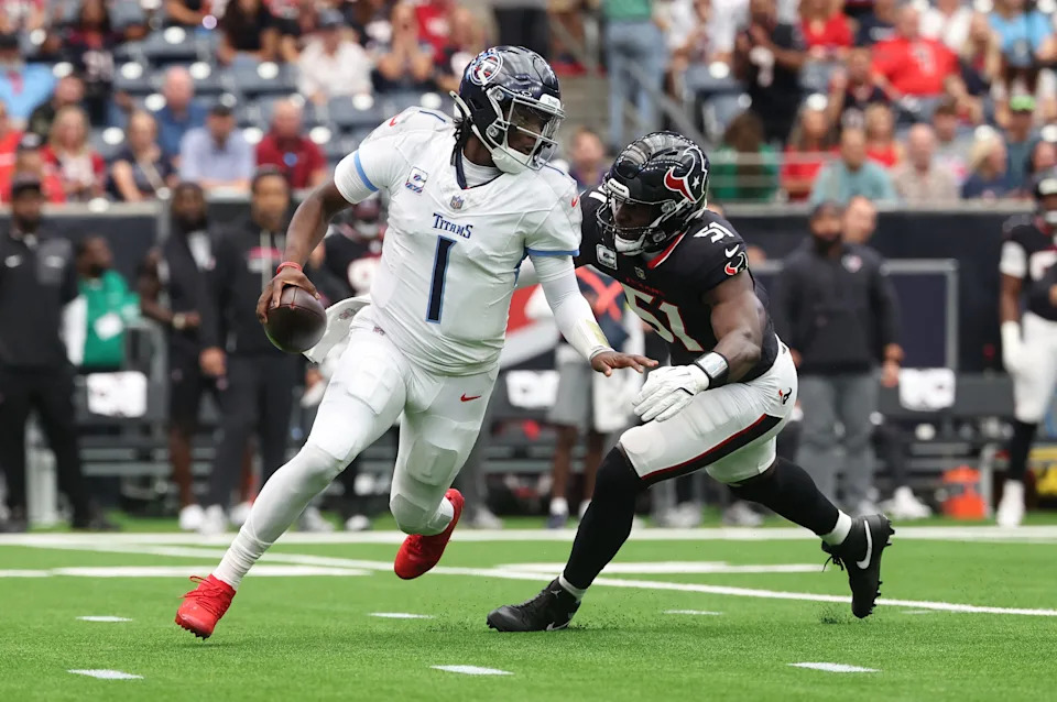 Sep 28, 2025; Houston, Texas, USA; Tennessee Titans quarterback Cam Ward (1) scrambles from Houston Texans defensive end Will Anderson Jr. (51) during the first half at NRG Stadium. Mandatory Credit: Troy Taormina-Imagn Images
