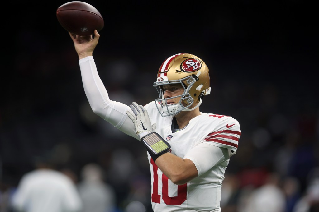 San Francisco 49ers quarterback Jimmy Garoppolo wearing number 10, holding a football.