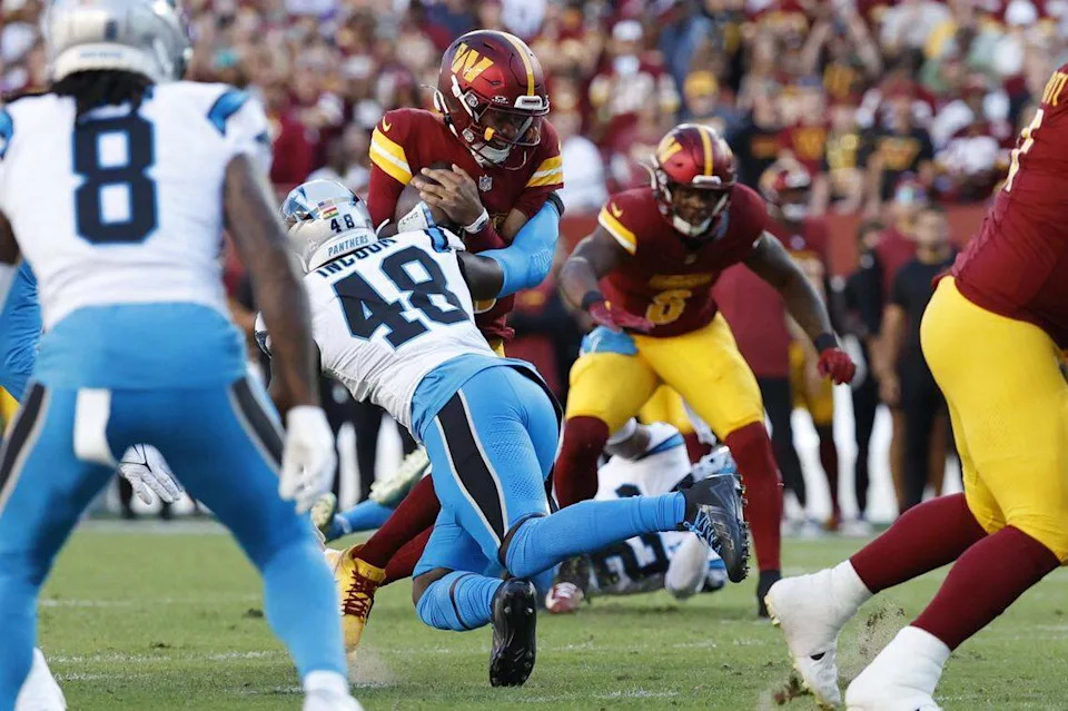 Washington Commanders quarterback Jayden Daniels (5) is tackled by Carolina Panthers linebacker Thomas Incoom (48) on Oct 20, 2024, in Landover, Maryland