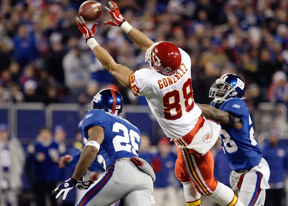 Kansas City Chiefs wide receiver Tony Gonzalez (C) misses a pass under pressure from New York Giants Brent Alexander (L) and Gibril Wilson (R) in the first quarter of their NFL game in East Rutherford, New Jersey December 17, 2005. REUTERS/Keith Bedford