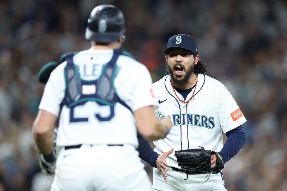Andrés Muñoz shouting as Cal Raleigh celebrates after the Seattle Mariners clinched a playoff spot.