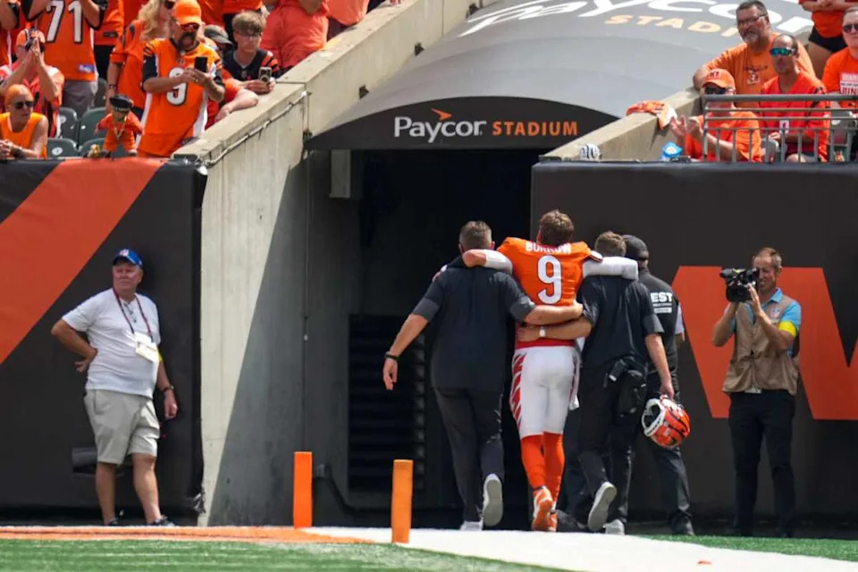 Cincinnati Bengals quarterback Joe Burrow (9) is assisted to the locker room with an injury in the second quarter of the NFL Week 2 game between the Cincinnati Bengals and the Jacksonville Jaguars at Paycor Stadium in downtown Cincinnati on Sunday, Sept. 14, 2025. The Jaguars led 17-10 at halftime.© Sam Greene/The Enquirer / USA TODAY NETWORK via Imagn Images