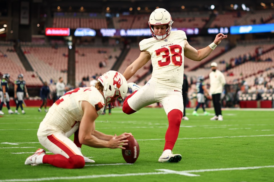 Arizona Cardinals player Chad Ryland #38 warming up with a football on the field.