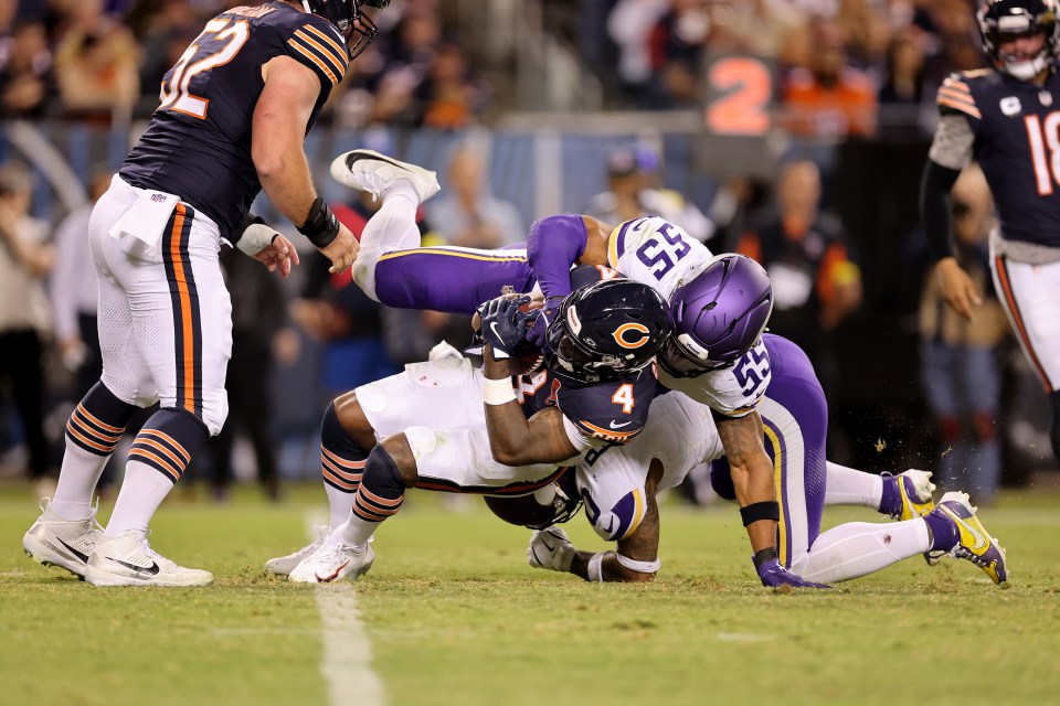 A Chicago Bears player being tackled by a Minnesota Vikings player.