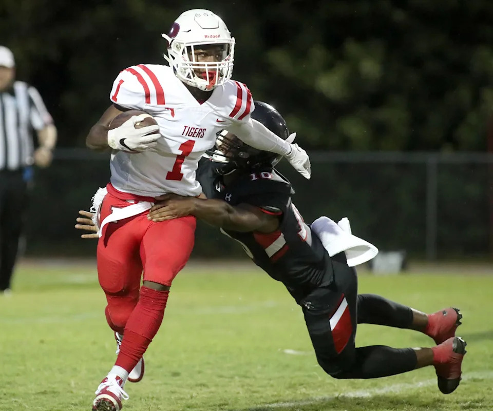 Palmetto's Lajohntay Wester (1) heads upfield for a gain as Port Charlotte's Steffon McGowan (10) trie to bring him down during Friday night action in Port Charlotte. ( Herald-Tribune photo / Matt Houston )