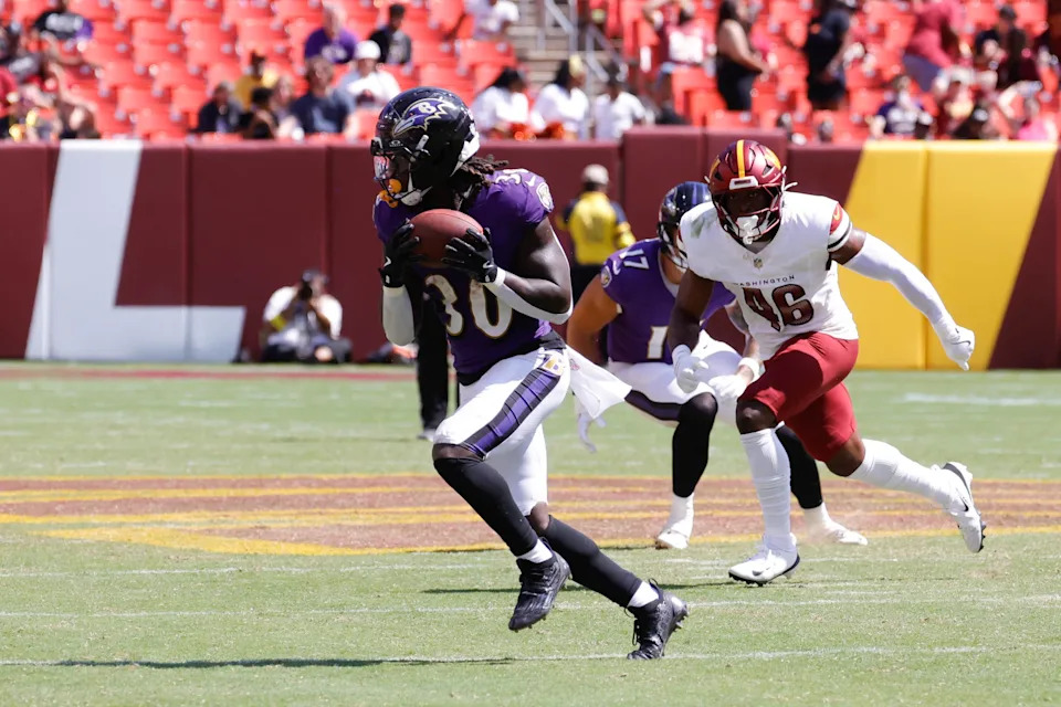 Aug 23, 2025; Landover, Maryland, USA; Baltimore Ravens running back D'Ernest Johnson (30) runs with the ball ahead of Washington Commanders linebacker Kam Arnold (46) in the fourth quarter at Northwest Stadium. Mandatory Credit: Jordyn Harris-Imagn Images