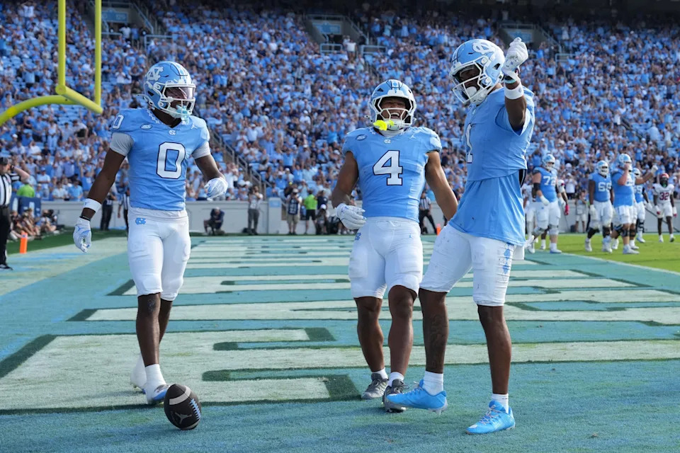 Sep 13, 2025; Chapel Hill, North Carolina, USA; North Carolina Tar Heels wide receiver Jordan Shipp (1) celebrates with wide receiver Alex Taylor (0) and running back Caleb Hood (4) after making a touchdown catch in the third quarter at Kenan Stadium. Mandatory Credit: Bob Donnan-Imagn Images