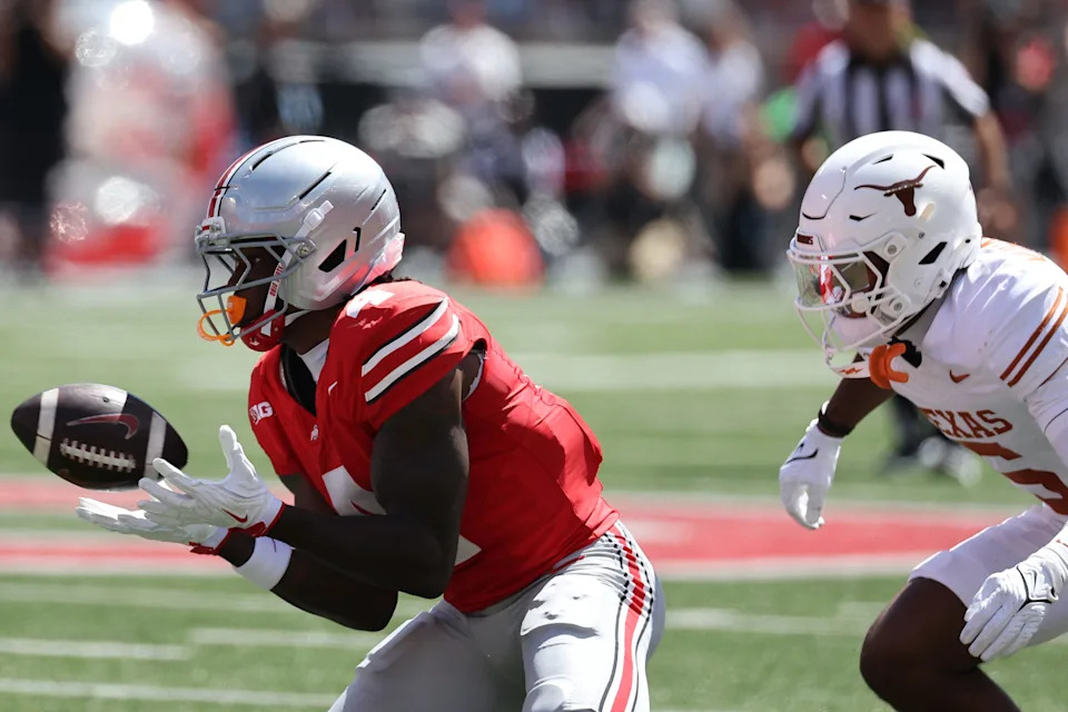 Aug 30, 2025; Columbus, Ohio, USA; Ohio State Buckeyes wide receiver Jeremiah Smith (4) makes a catch against Texas Longhorns defensive back Malik Muhammad (5) in the first half at Ohio Stadium. Mandatory Credit: Joseph Maiorana-Imagn Images