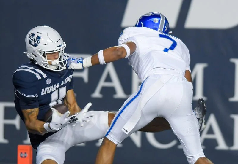 Utah State wide receiver Braden Pegan (11) catches a 38-yard touchdown pass as Air Force linebacker Luke Meyer (7) defends during the second half Saturday Sept. 13, 2025, in Logan, Utah. | Eli Lucero/Herald Journal