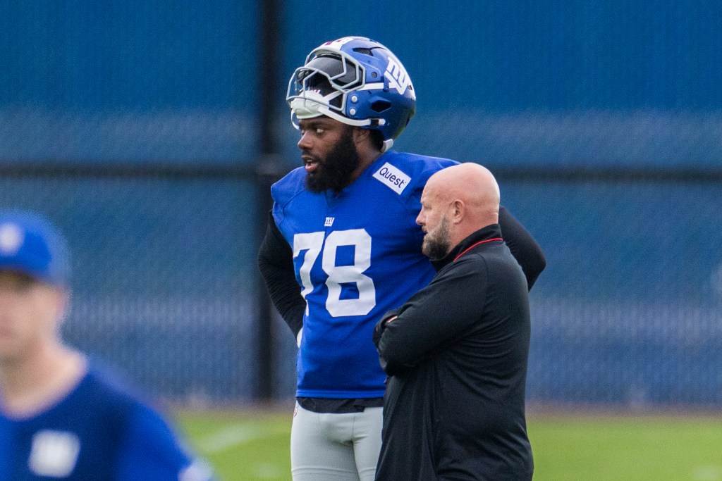 New York Giants offensive tackle Andrew Thomas speaking with head coach Brian Daboll.