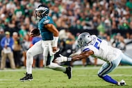 Dallas Cowboys defensive end Sam Williams (54) tries to trip Philadelphia Eagles quarterback...