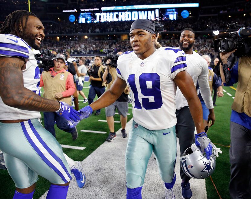 Dallas Cowboys wide receiver Amari Cooper (19) is congratulated by teammates after scoring...