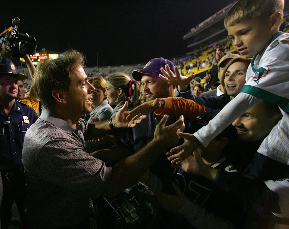 Miami Dolphins head coach Nick Saban shakes fans hands as he leaves the field after the Dolphins 21-6 victory over the New Orleans Saints at Tiger Stadium.