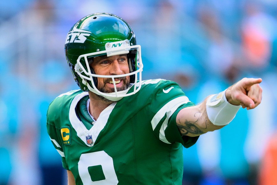 Aaron Rodgers, New York Jets quarterback, smiles and points.