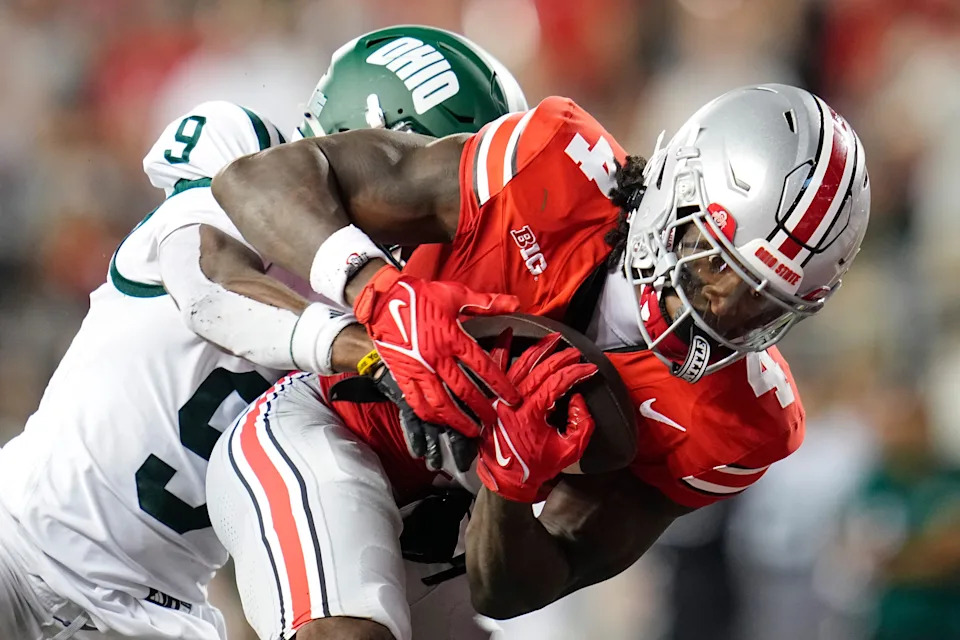 Ohio State Buckeyes wide receiver Jeremiah Smith (4) catches a 47-yard touchdown pass in front of Ohio Bobcats cornerback Michael Mack II (9) during the second half of the NCAA football game at Ohio Stadium on Sept. 13, 2025. Ohio State won 37-9.