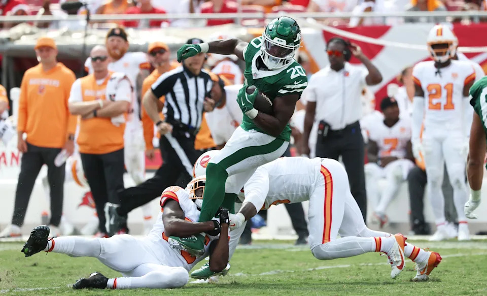 Sep 21, 2025; Tampa, Florida, USA; Tampa Bay Buccaneers outside linebacker Haason Reddick (5) and cornerback Jamel Dean (35) tackle New York Jets running back Breece Hall (20) during the second half at Raymond James Stadium. Mandatory Credit: Kim Klement Neitzel-Imagn Images