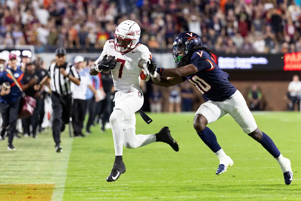 CHARLOTTESVILLE, VIRGINIA - SEPTEMBER 26: Ja'Son Prevard #10 of the Virginia Cavaliers pushes Lawayne McCoy #7 of the Florida State Seminoles out of bounds in overtime during a game at Scott Stadium on September 26, 2025 in Charlottesville, Virginia.