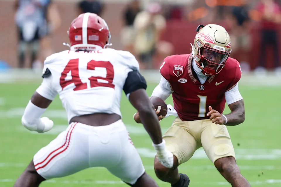 Tommy Castellanos of the Florida State Seminoles scrambles for yardage as he tries to get around Yhonzae Pierre of the Alabama Crimson Tide during the second quarter of a football game at Doak Campbell Stadium on August 30, 2025 in Tallahassee, Florida.
