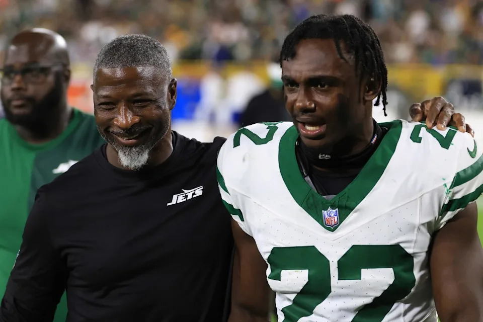 Aaron Glenn and Tony Adams (22) walk off the field. Getty Images